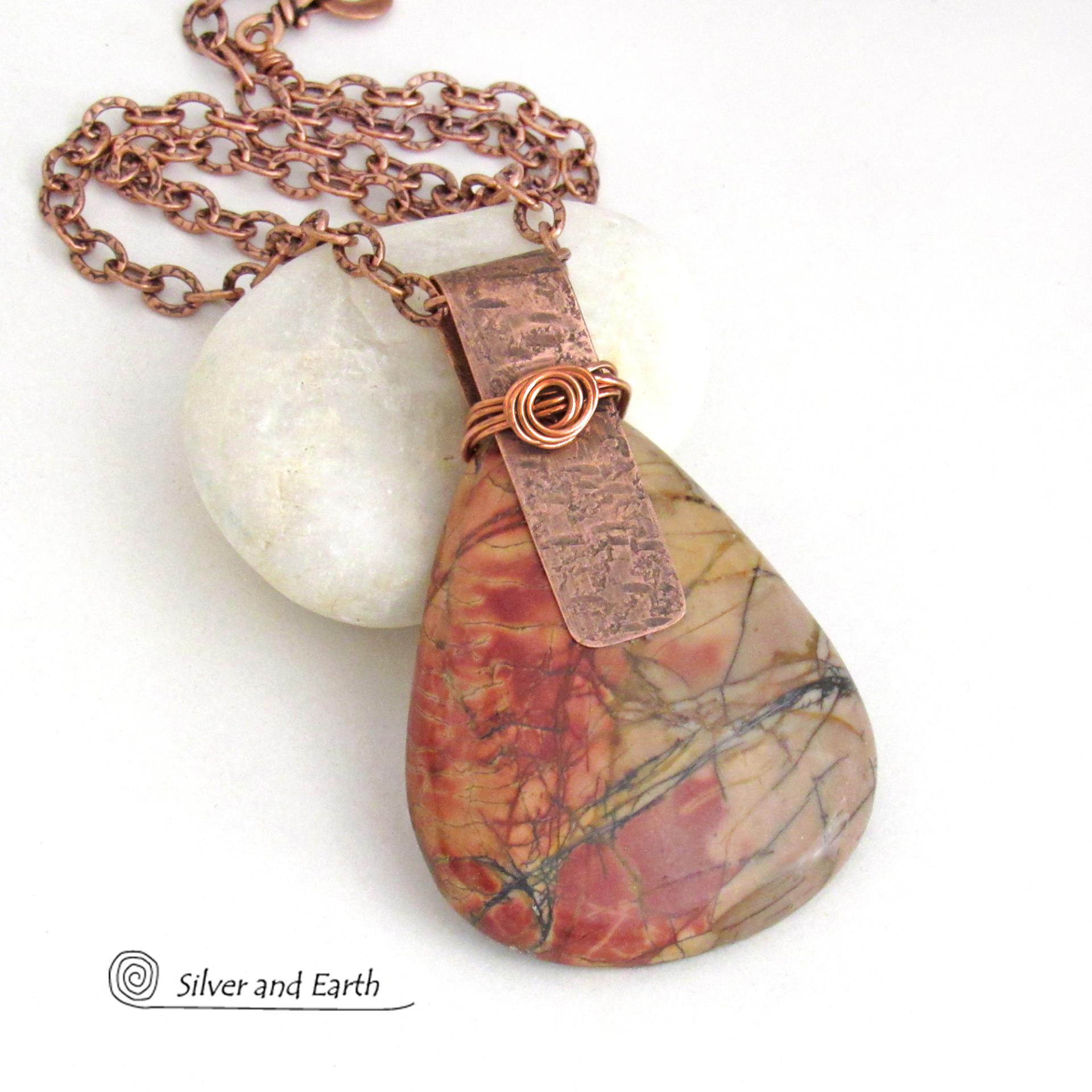 This one-of-a-kind necklace features a large stunning red creek jasper stone accented with a handcrafted copper bail. The stone has a natural pattern in beautiful earthy shades of brick red, orange and taupe with streaks of black veining. Big and bold, this necklace is a real statement piece - perfect for anyone that loves natural stones!