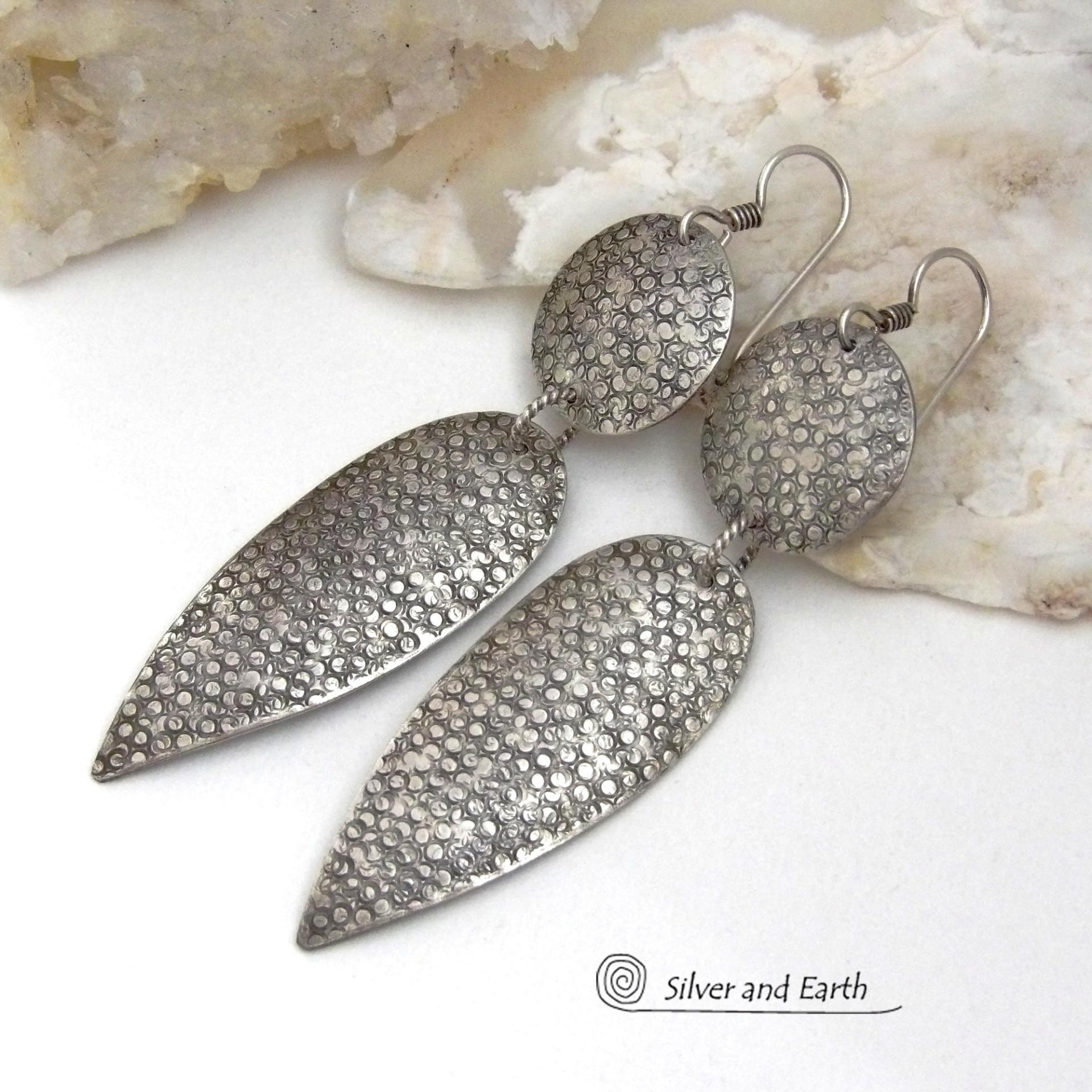 Bold, modern and contemporary - these long handcrafted sterling silver earrings feature an intricate hand textured design. They have an urban chic appeal and will look great with all wardrobe styles. They go with everything! Earrings are sturdy & substantial - yet lightweight and comfortable for all day wear.   MEASUREMENTS: Total length: 3" from top of sterling silver ear wires and 3/4” at widest point. Handmade in the USA by Silver and Earth Jewelry. 