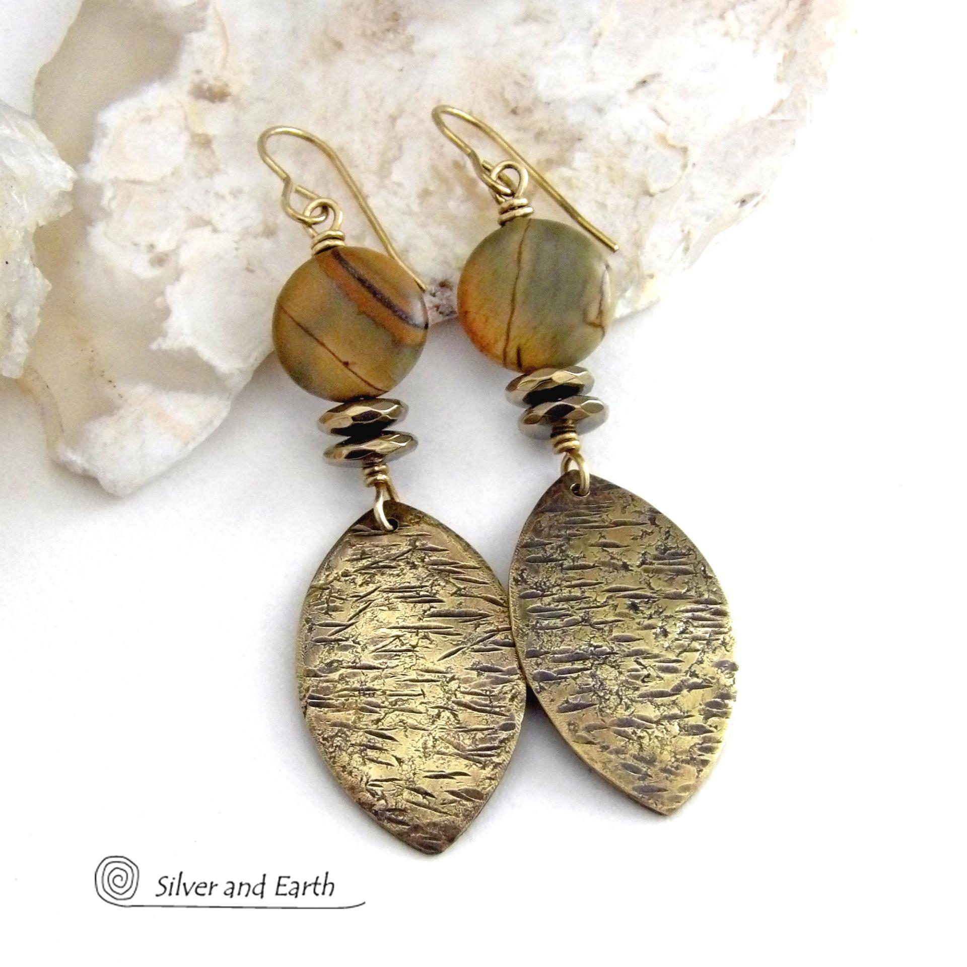 These handcrafted earrings feature textured gold brass dangles accented with natural Picasso jasper gemstones and hematite stone beads. The beads have an electroplated champagne gold tone finish which adds a touch of shimmer and shine. They have an earthy modern style that coordinates well with all wardrobe styles. Coordinating necklace is available and sold separately.