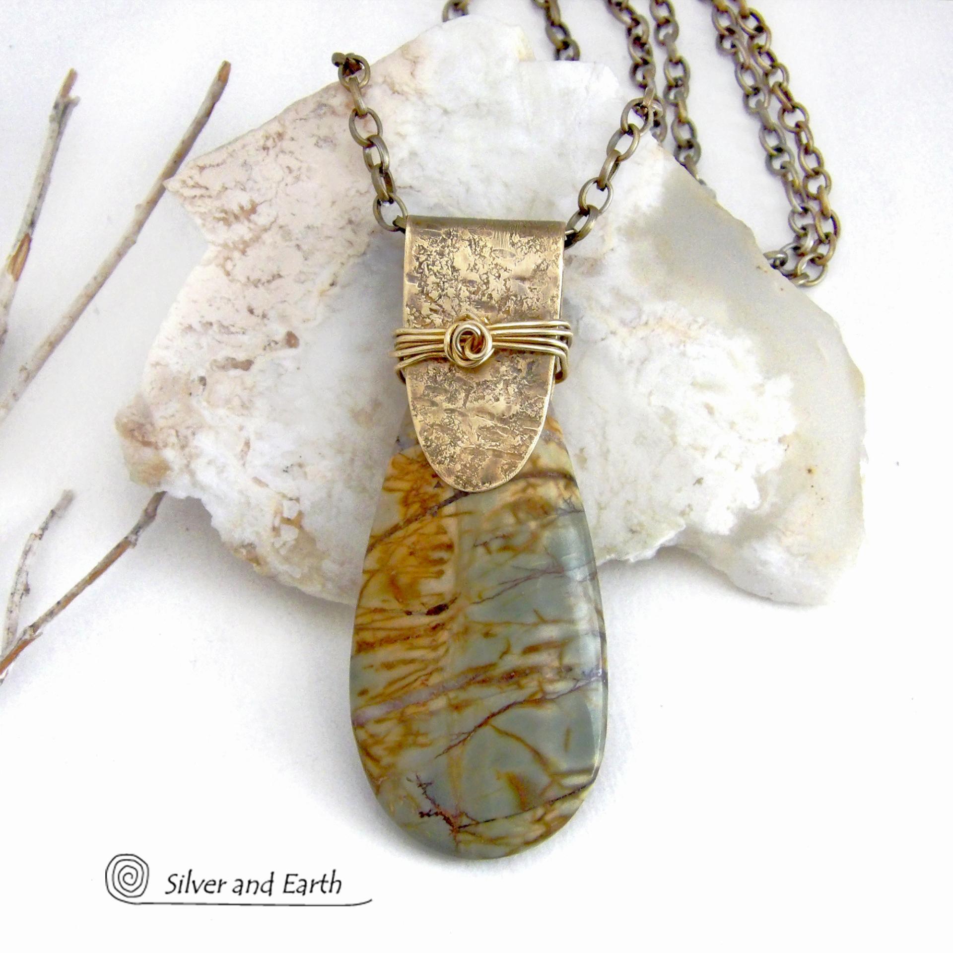 This handcrafted necklace features a natural Picasso jasper gemstone accented with a gold brass bail. The stone has a beautiful matrix with earthy hues of soft yellow, light mossy green and brown streaks. It has an earthy, modern style that coordinates beautifully with all wardrobe types. Unique and one of a kind, it makes a great gift for a natural stone lover - or a nice addition to your own jewelry collection. Comes on a 20" antiqued brass chain with lobster claw closure.  