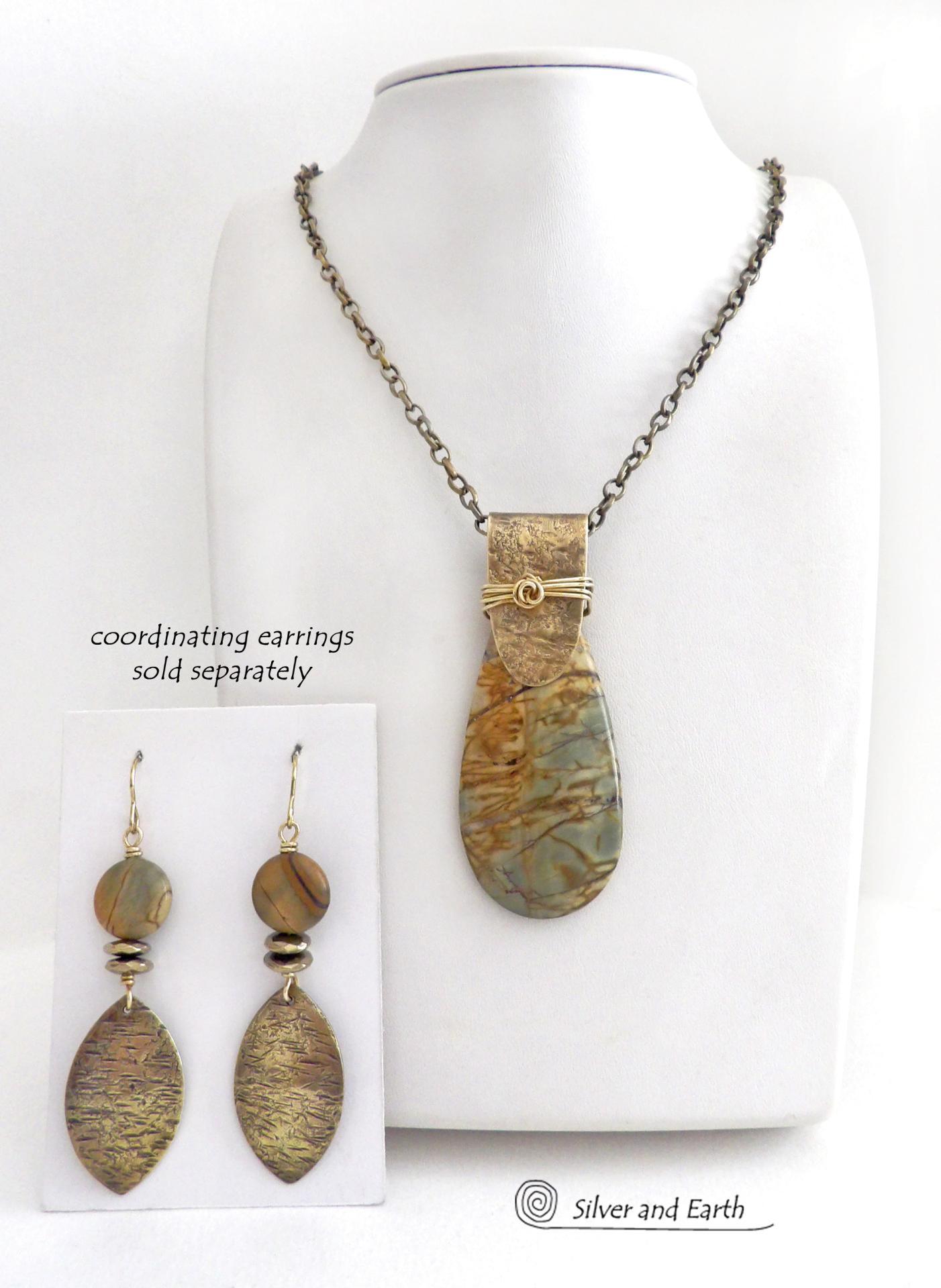 This handcrafted necklace features a natural Picasso jasper gemstone accented with a gold brass bail. The stone has a beautiful matrix with earthy hues of soft yellow, light mossy green and brown streaks. It has an earthy, modern style that coordinates beautifully with all wardrobe types. Unique and one of a kind, it makes a great gift for a natural stone lover - or a nice addition to your own jewelry collection. Comes on a 20" antiqued brass chain with lobster claw closure.  