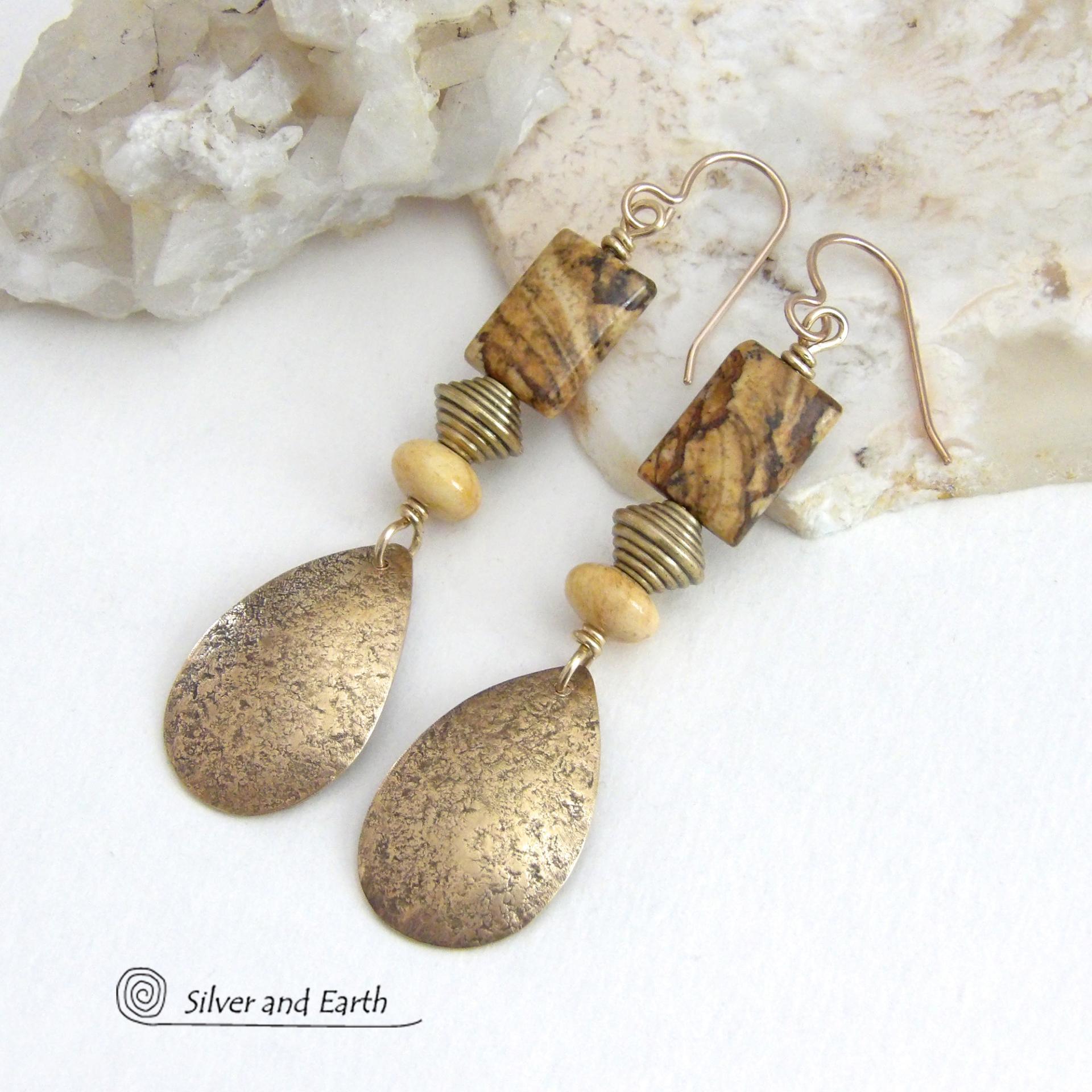 These handcrafted earrings feature gold brass teardrop dangles with a lightly hammered organic texture accented with natural picture jasper stones, brass and fossilized beige coral beads. They have an earthy natural style that coordinates beautifully with all wardrobe styles. Earrings have a coordinating necklace sold separately. Handmade in the USA by Silver and Earth Jewelry.