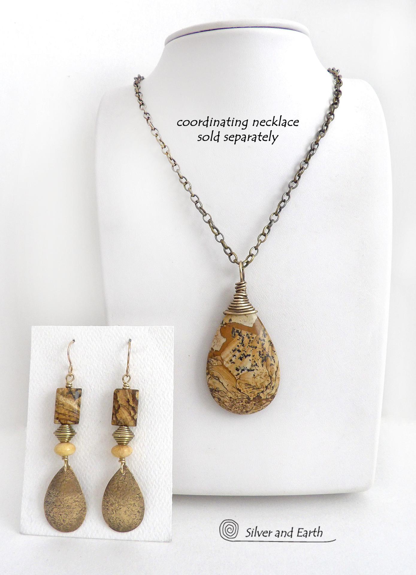These handcrafted earrings feature gold brass teardrop dangles with a lightly hammered organic texture accented with natural picture jasper stones, brass and fossilized beige coral beads. They have an earthy natural style that coordinates beautifully with all wardrobe styles. Earrings have a coordinating necklace sold separately. Handmade in the USA by Silver and Earth Jewelry.