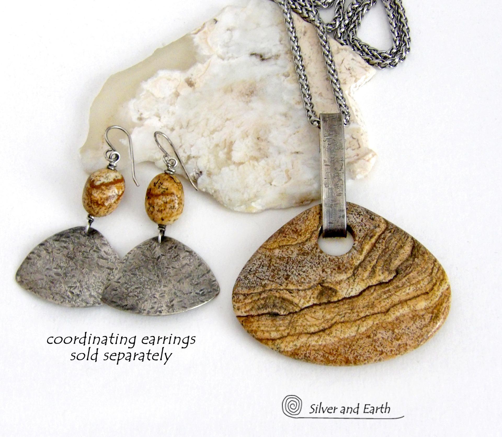 This handcrafted necklace features a large, chunky natural picture jasper stone accented with a handcrafted sterling silver bail. The stone has a beautiful natural pattern in various shades of brown, beige and gray. Big and bold, this necklace is a real one-of-a-kind statement piece - perfect for anyone that loves natural stones! It's reversible and can be worn on either side. Coordinating earrings sold separately. Handmade in the USA by Silver and Earth Jewelry.