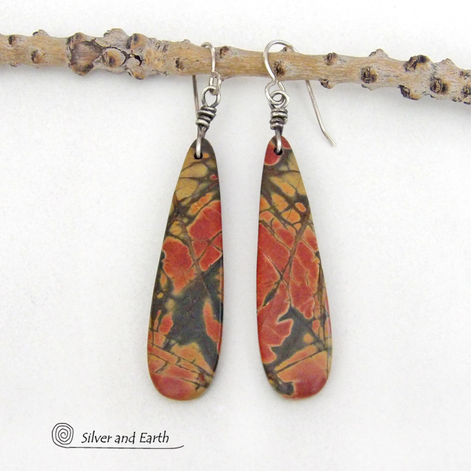 Full of earthy charm - these one-of-a-kind earrings feature long natural red creek jasper stones dangling from sterling silver ear wires. The stones have a beautiful natural pattern in earthy hues of mossy greens, brick red, orange and subtle hints of golden yellow. They'll make a great gift for anyone that loves natural stones!