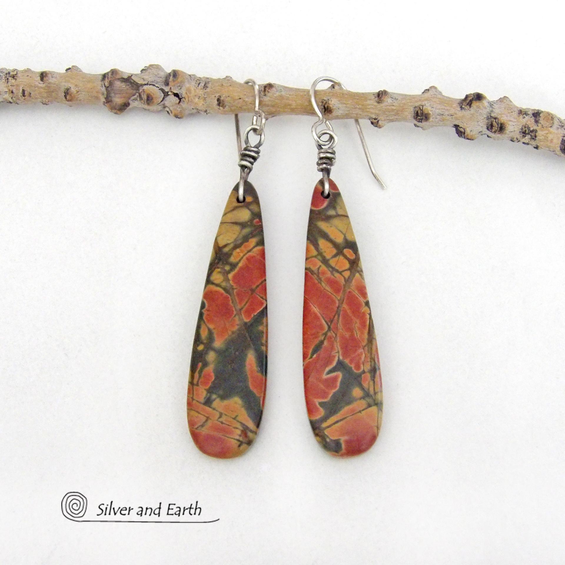 Full of earthy charm - these one-of-a-kind earrings feature long natural red creek jasper stones dangling from sterling silver ear wires. The stones have a beautiful natural pattern in earthy hues of mossy greens, brick red, orange and subtle hints of golden yellow. They'll make a great gift for anyone that loves natural stones!