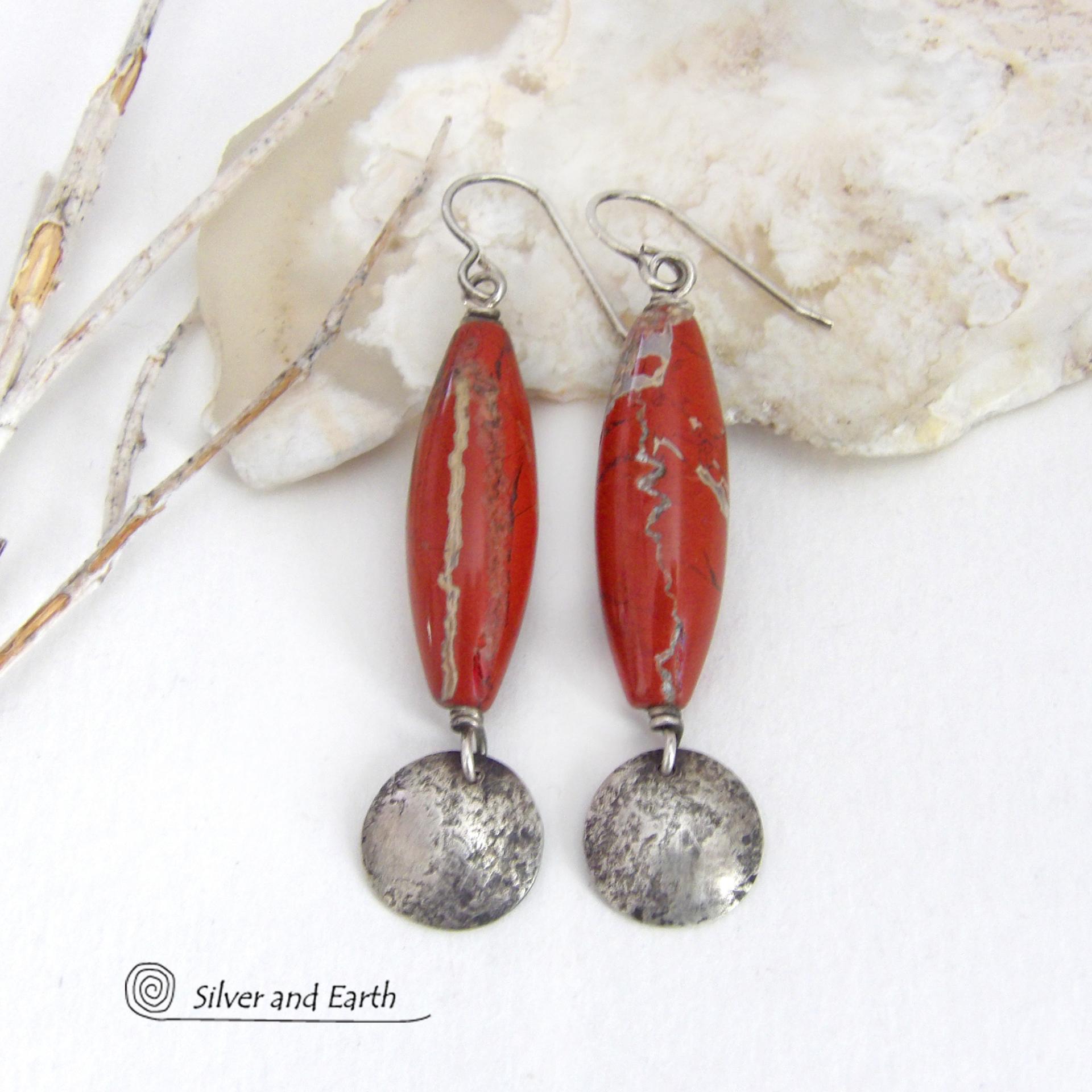 These handmade earrings feature natural red jasper gemstones accented with small hammered sterling silver dangles. The stones have a brick red hue with an interesting matrix of beige streaks and squiggly lines. They have a modern, earthy appeal that coordinates well with all wardrobe styles. They'll make a great gift for a natural stone lover - or a nice addition to your own jewelry wardrobe. They have a coordinating necklace which is sold separately. Handmade in the USA by Silver and Earth Jewelry.  