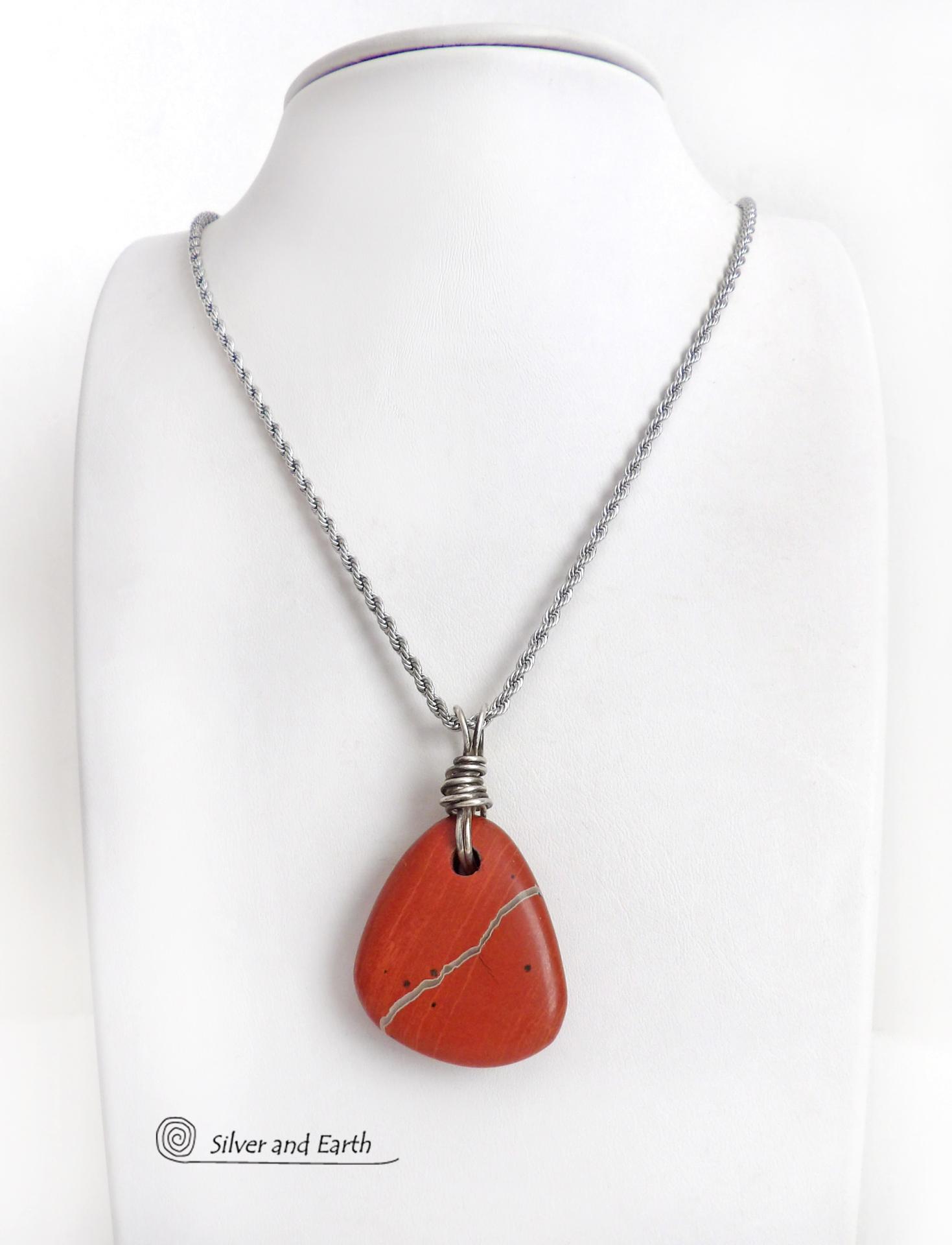 Simple and earthy - this pendant necklace features a natural red jasper gemstone with a wire wrapped sterling silver bail. The stone has a brick red hue with a natural matrix of beige streaks and dots. It has a modern minimalist appeal and is perfect for those that prefer simple, earthy jewelry. It has coordinating earrings which are sold separately. It makes a great gift for a natural stone lover - or a nice addition to your own jewelry wardrobe. Handmade in the USA by Silver and Earth Jewelry. 
