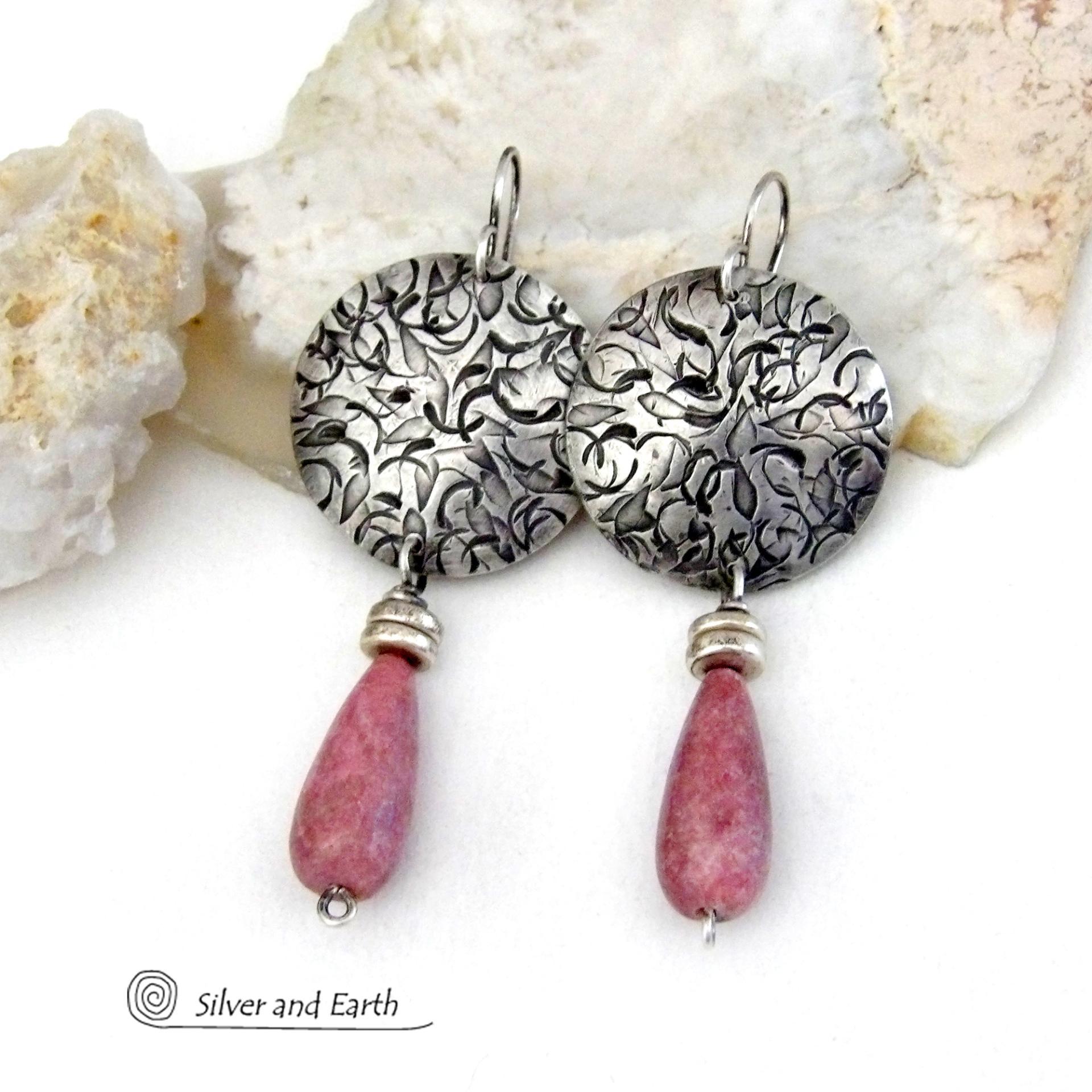 These handmade sterling silver earrings have a modern, classic design that will always be in fashion. They feature natural rhodonite gemstones dangling from textured sterling silver. The stones have a slender teardrop shape and a dark rosy pink hue with subtle brown inclusions. They are accented with tiny pewter beads. Perfect for all occasions -- they'll look great dressed up or down.