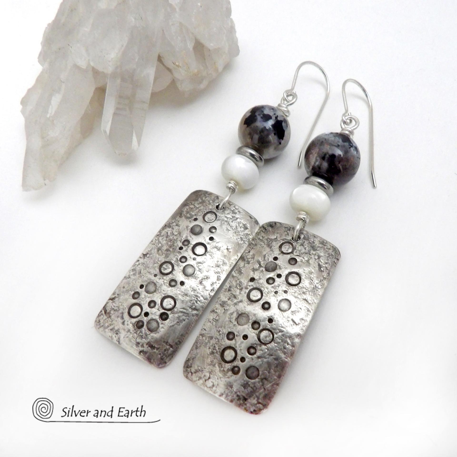 These handcrafted sterling silver earrings have a hand stamped and lightly hammered organic texture and are accented with natural sunstone / moonstone gemstones and mother of pearl and small stainless steel beads. This hybrid stone is rare and found only in Tanzania. It has beautiful shimmery hues of black with natural silvery flashes and subtle peach and gold inclusions. These earrings have a modern, elegant chic style that looks great dressed up or down. Perfect for women that love unique gemstone jewelry