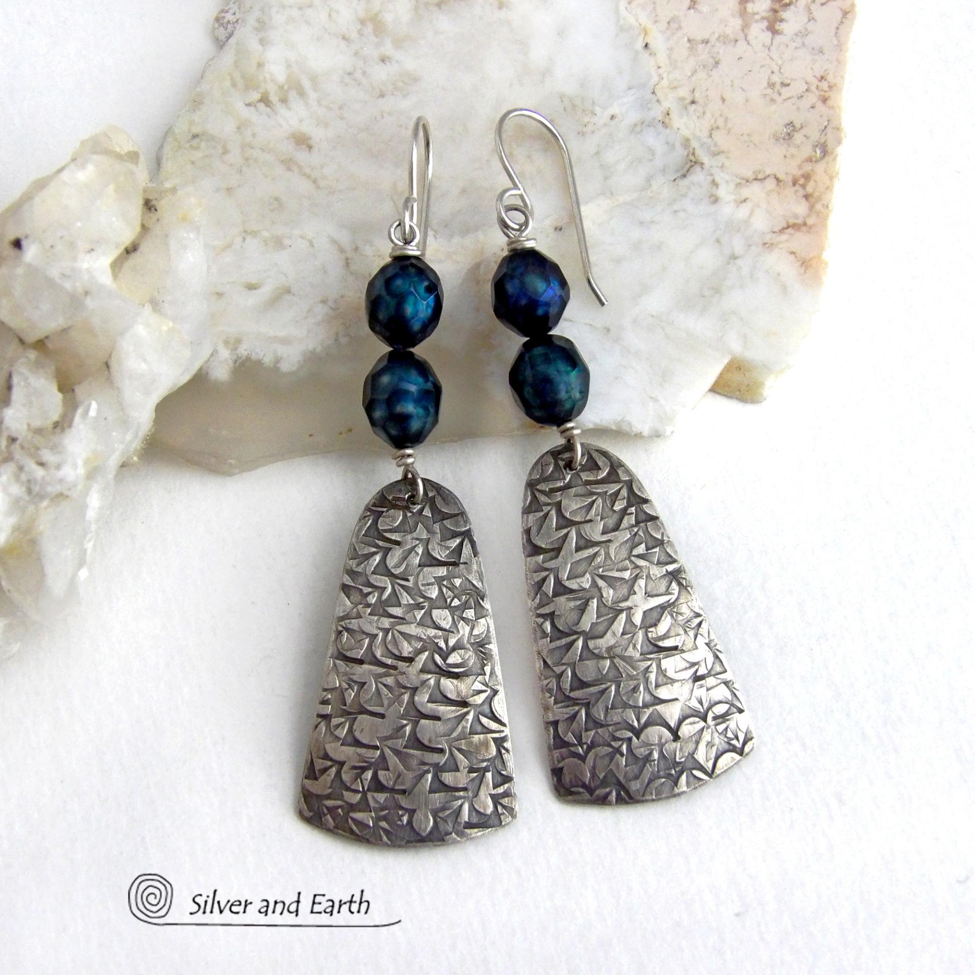 These sterling silver earrings feature handcrafted sterling silver dangles with an intricate hand stamped texture accented with deep teal blue freshwater pearls with a faceted finish.  They have a modern, elegant feel and will look great dressed up or down. They dangle from sterling silver ear wires. Handmade in the USA by Silver and Earth Jewelry. 