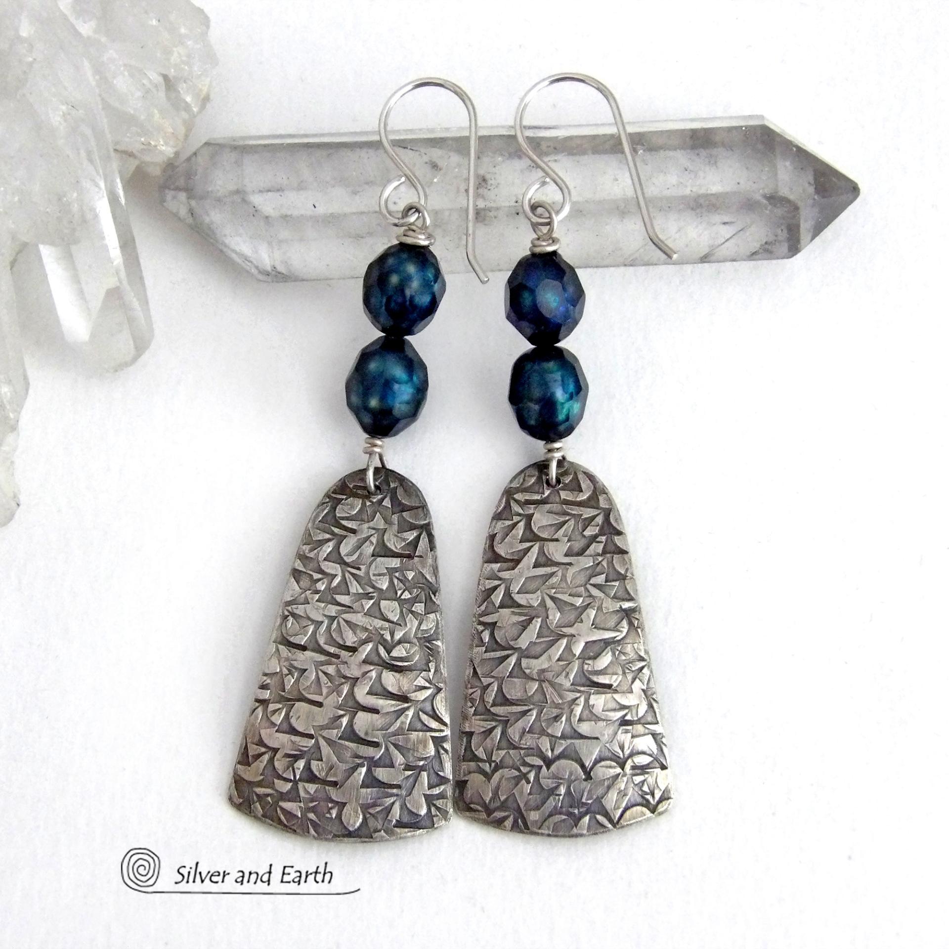 These sterling silver earrings feature handcrafted sterling silver dangles with an intricate hand stamped texture accented with deep teal blue freshwater pearls with a faceted finish.  They have a modern, elegant feel and will look great dressed up or down. They dangle from sterling silver ear wires. Handmade in the USA by Silver and Earth Jewelry. 
