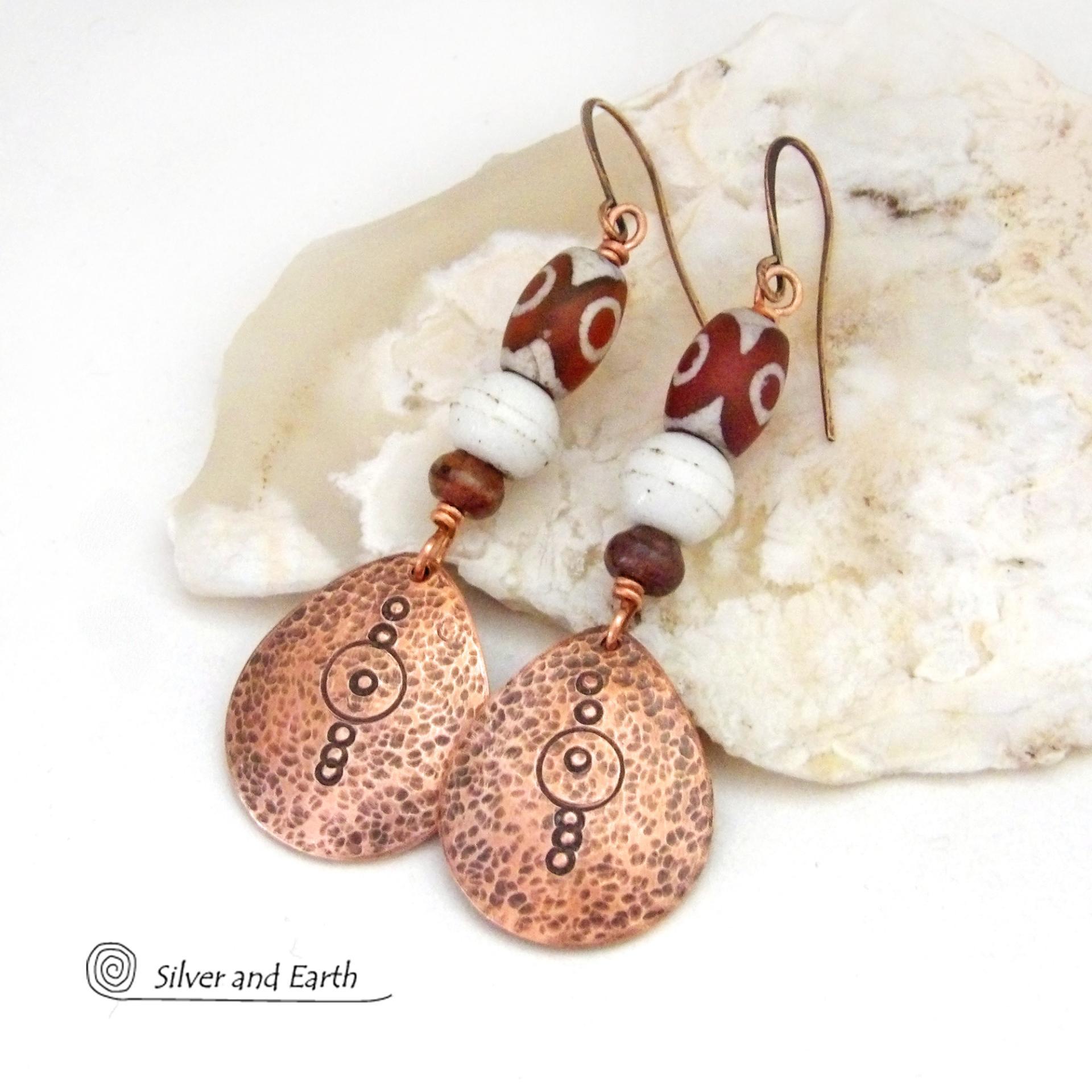 These handmade copper earrings have a hammered and hand stamped texture and are accented with Tibetan etched agate stones, African glass beads and small brown jasper stones. They have an ethnic, boho chic flair and are fun to wear.